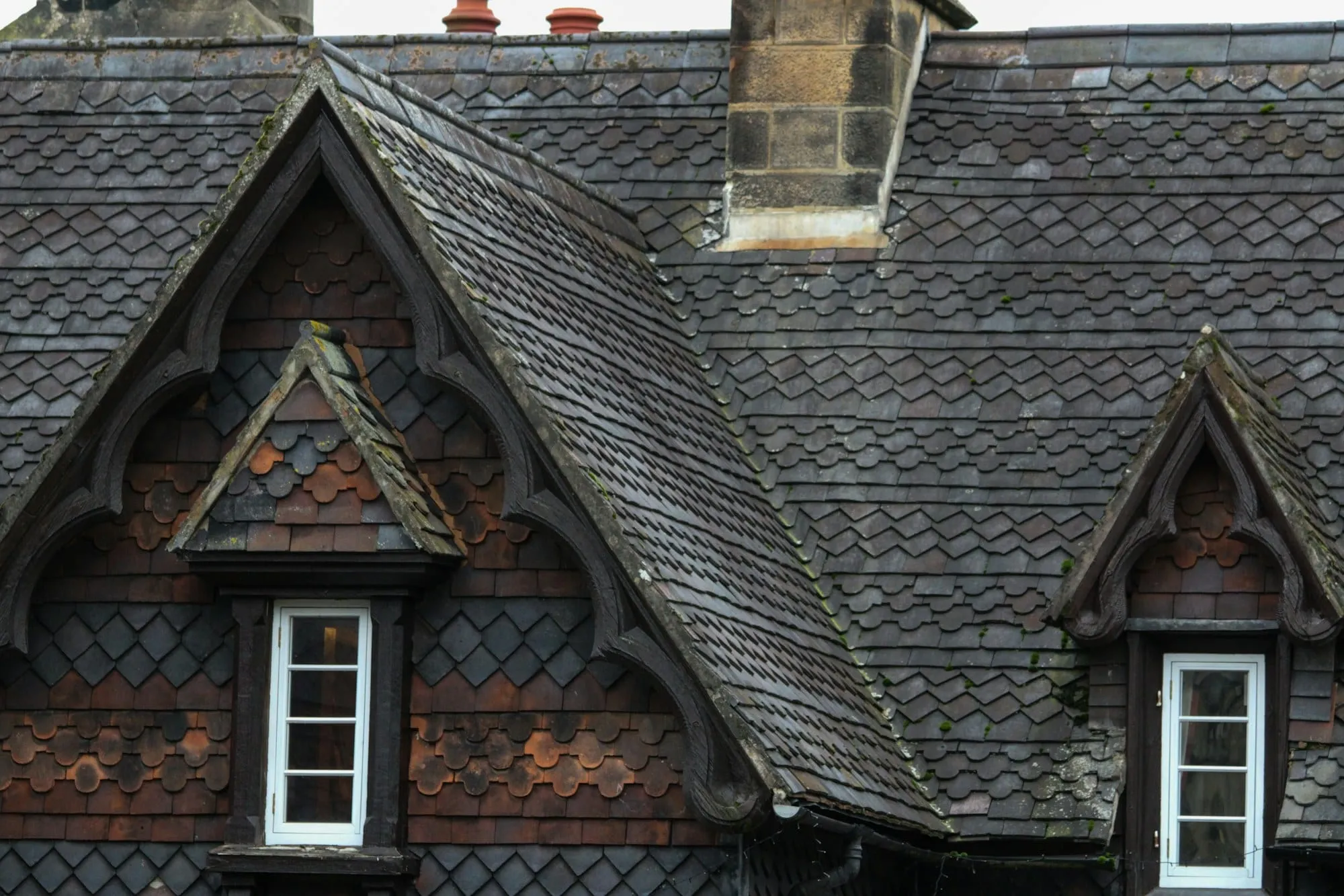 Slate roof with decorative dormer windows on a Victorian house