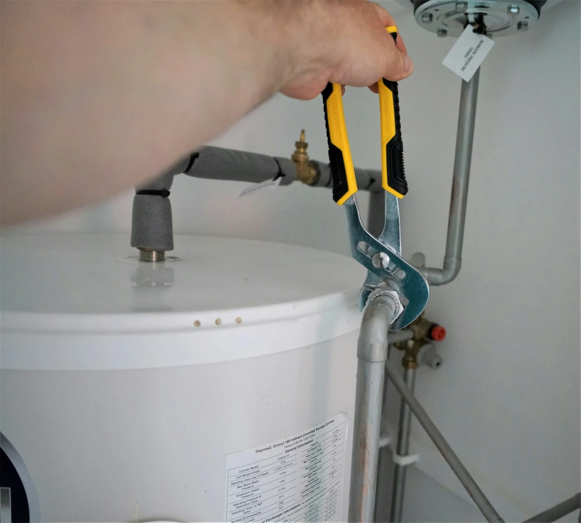 Plumber tightening a fitting on a water heater